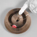 Cat playing with the ball in the cardboard scratcher groove