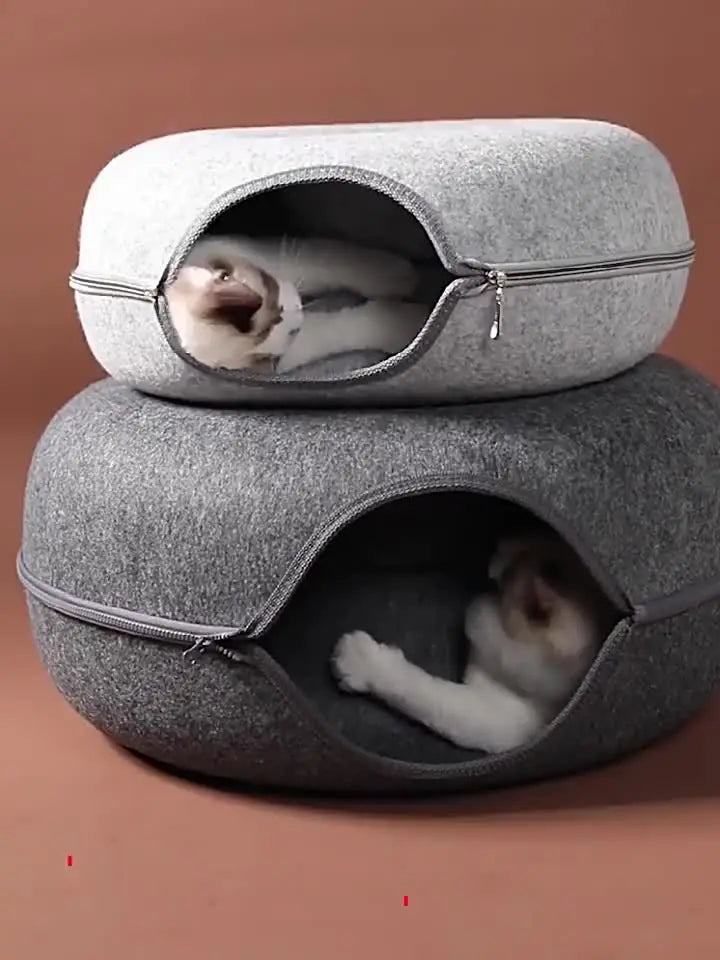 Two cats resting inside stacked felt donut cat caves
